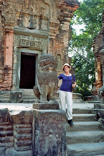 Annie standing next to a stone statue outside a temple.